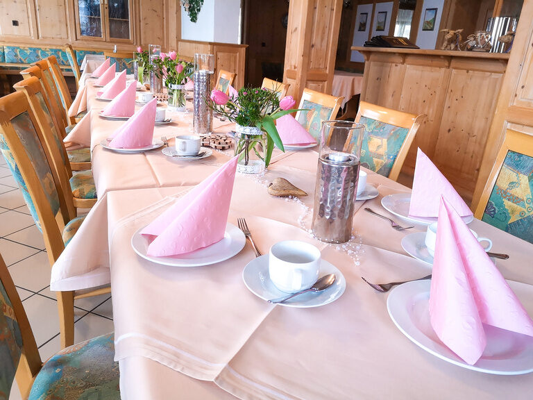 Ein modern gedeckter Esstisch im Restaurant mit weißer Tischdecke.